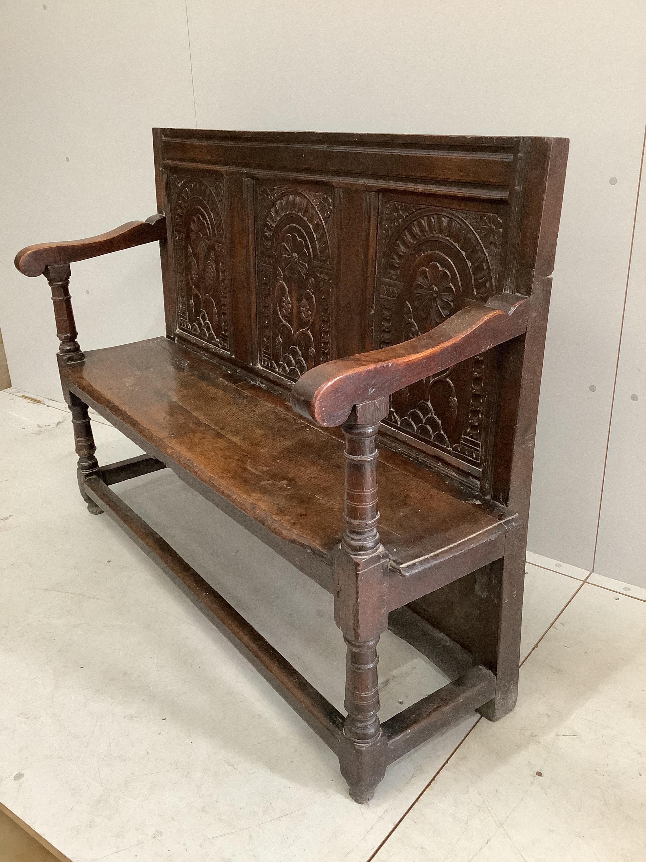 An 18th century style oak settle, incorporates old timber, width 130cm, depth 44cm, height 99cm